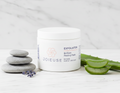 Joieuse exfoliator jar with peeling pads on a white surface with aloe vera and stones.
