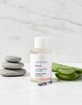 Joieuse skincare bottle with aloe vera and stones on a marble background